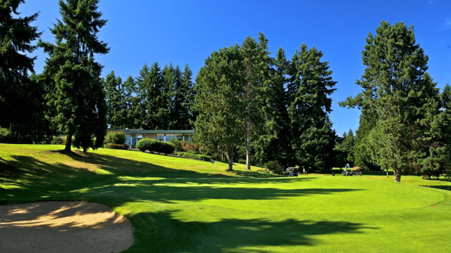 View of golf course with trees and bunker